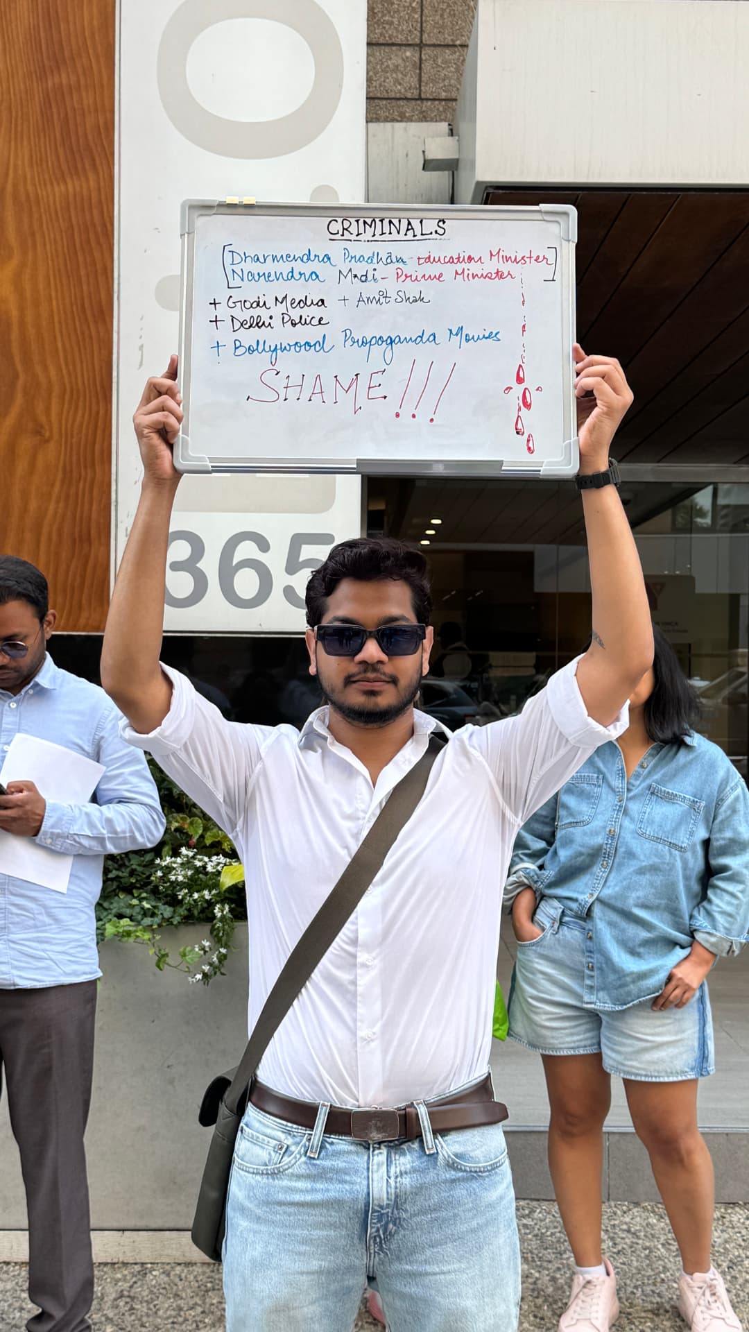 Satvik holding a sign at a protest in Toronto